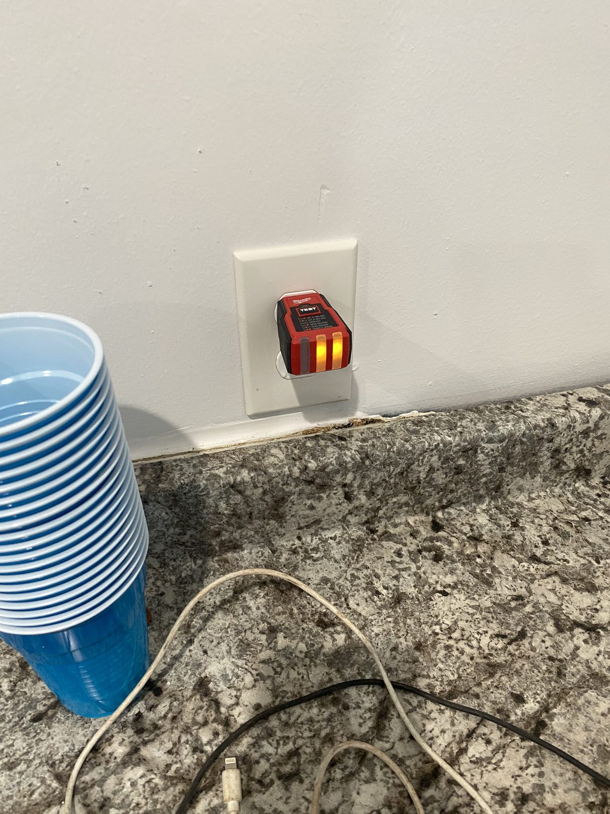 Completed electrical outlet installation with tester showing correct wiring